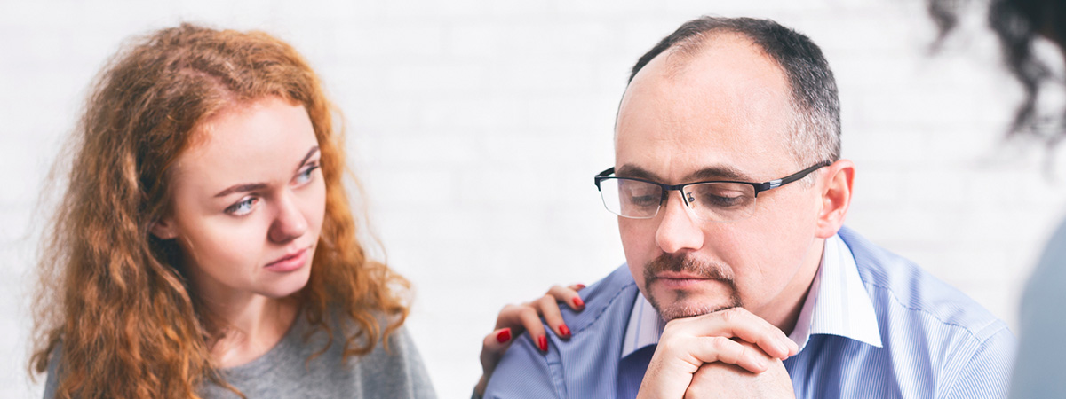  Supportive wife comforting husband with TRD during a meeting with a counselor in West Caldwell.